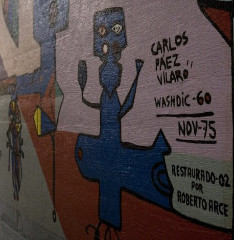 Mural en un tunel con colores rojo, azul y firma del artista